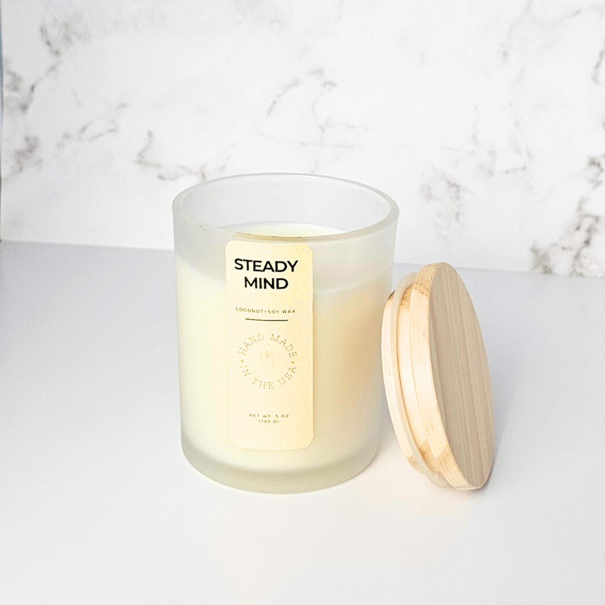 Wickless Candle with a wooden lid labeled 'Steady Mind' on a marble surface