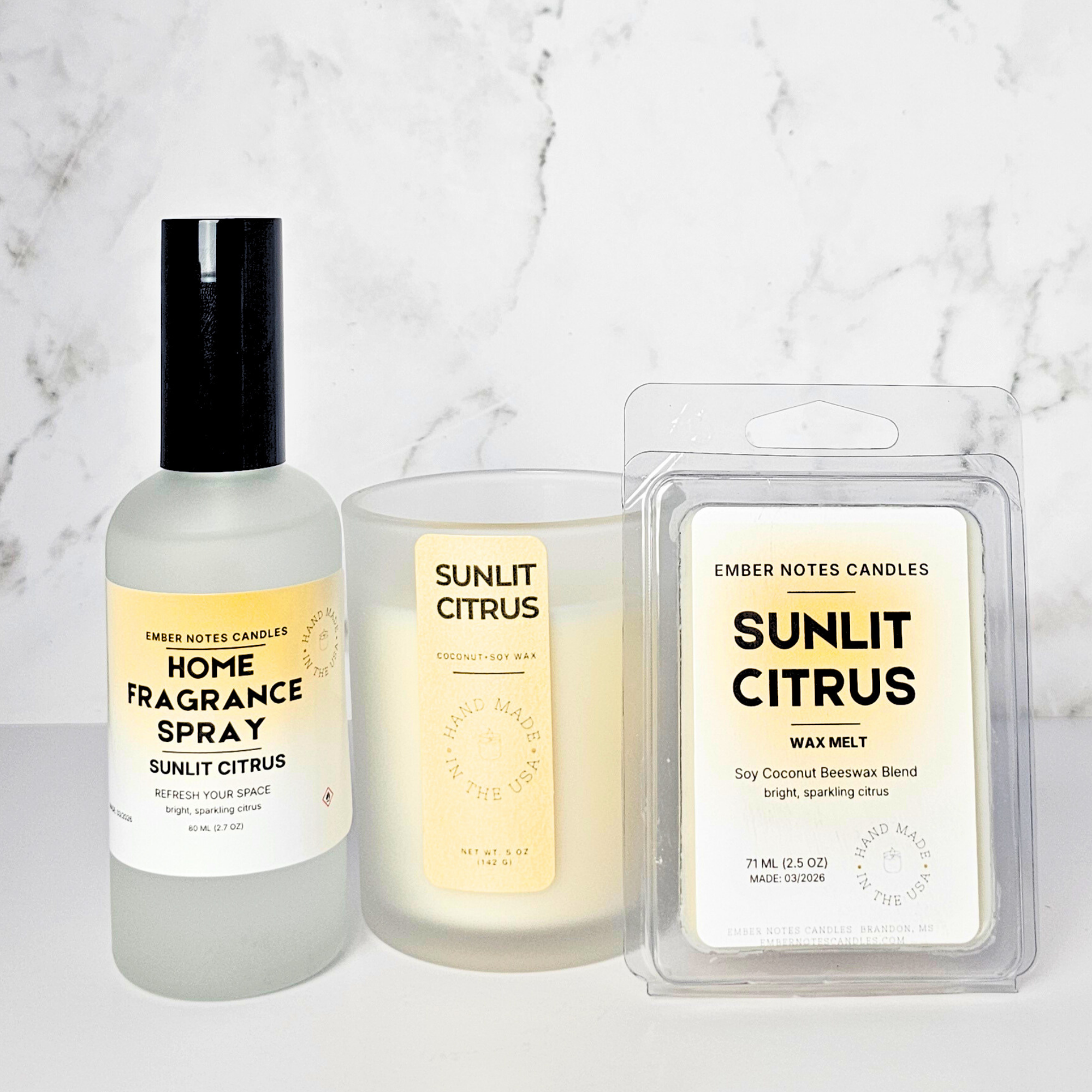 Sunlit Citrus fragrance spray, candle, and wax melt set on a marble background