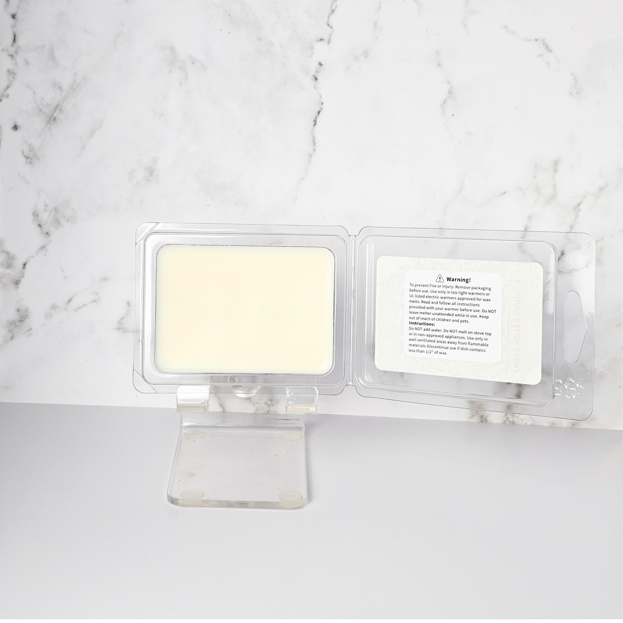Wax melts in clear packaging on a marble surface