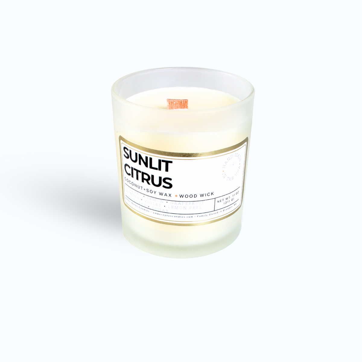 Candle in front of a white background with the label sunlit Citrus 