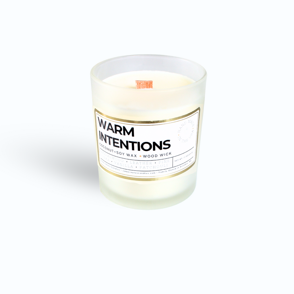 A candle with a label that says Warm Intentions
